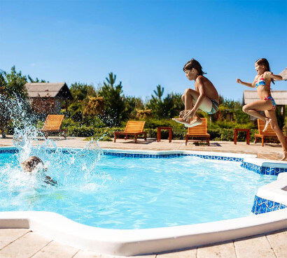 niños saltando hacia la piscina