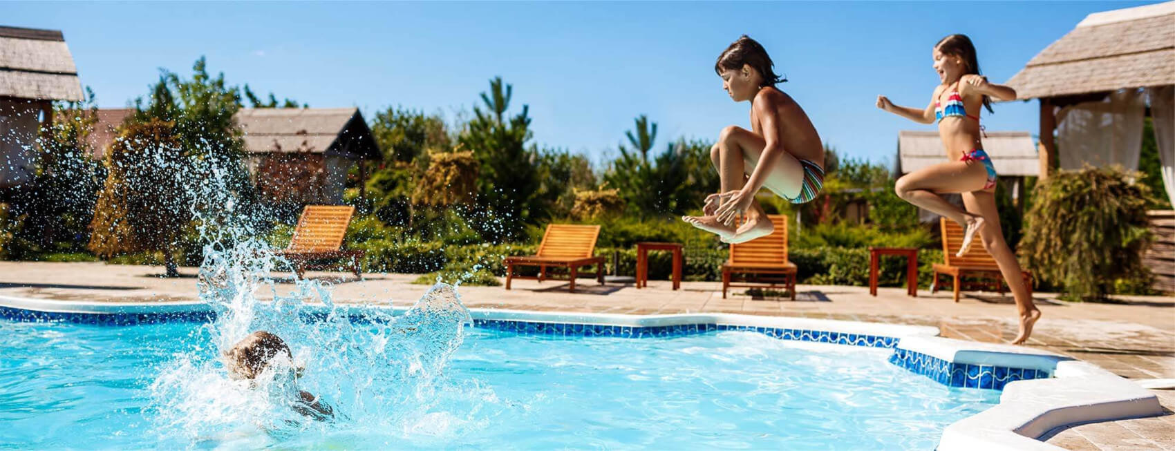 niños saltando hacia la piscina